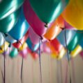 Brightly coloured helium filled balloons with strings hanging down