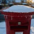 Decorative image of a snow-topped Royal Mail red postbox